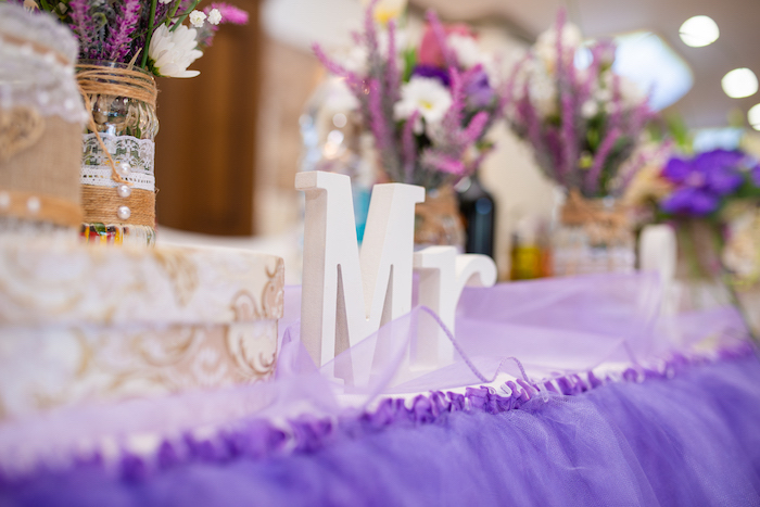 Tischdeko für Hochzeit in Lila und Weiß, weiße Buchstaben aus Holz, Vasen mit Spitze und Perlen dekoriert