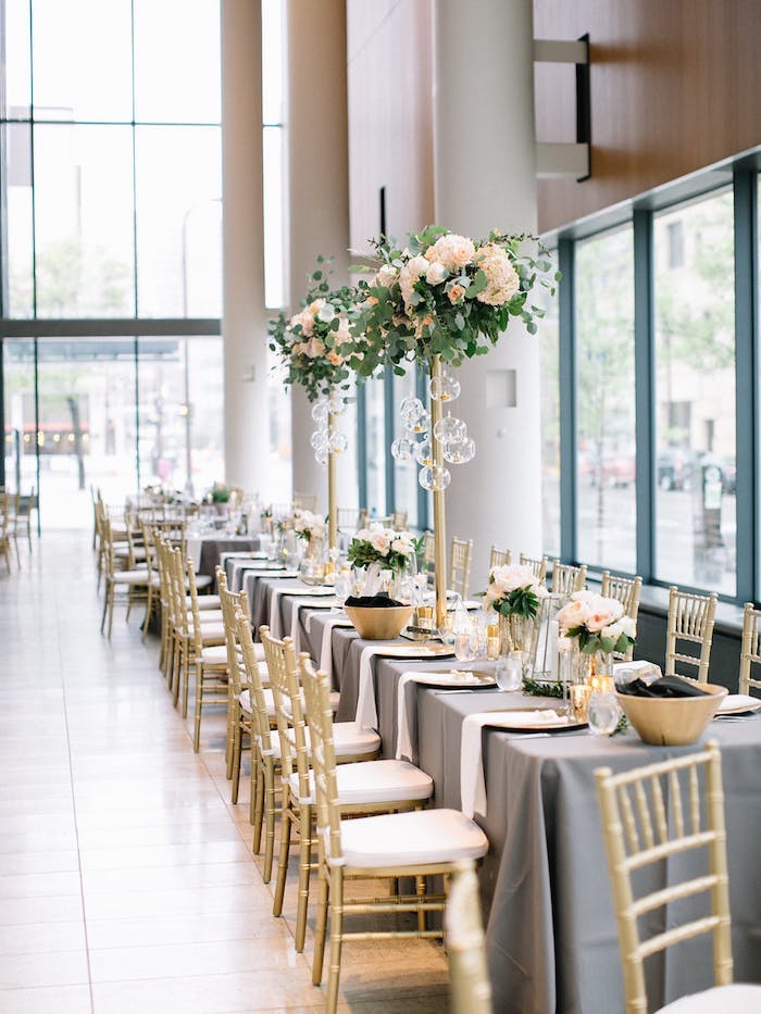 Prachtvolle Tischdekoration für Hochzeit mit vielen Blumen, weiße Rosensträuße in der Luft