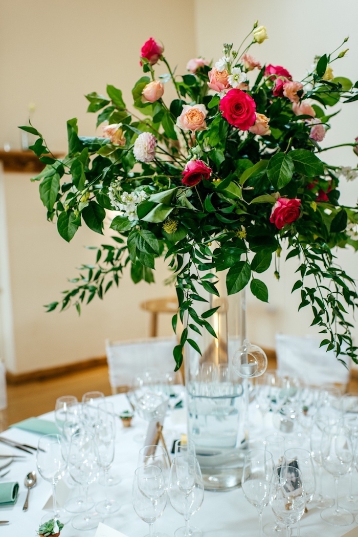 Gläser und Vase aus Kristall, großer Blumenstrauß, weiße Tischdecke