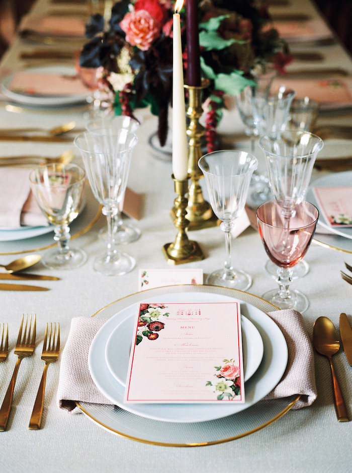 Menü mit Blumenmuster, goldene Kerzenhalter, Gläser aus Kristall, weiße Tischdecke
