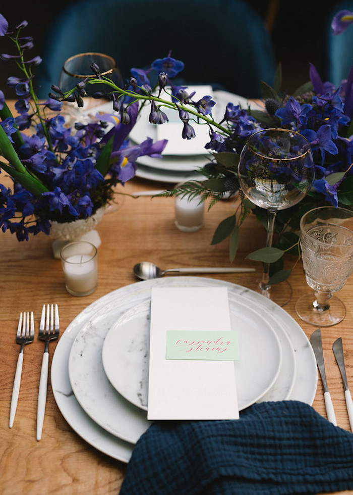 Stilvolle Tischdeko für Hochzeit, blaue und violette Blumen, dunkelblaue Servietten