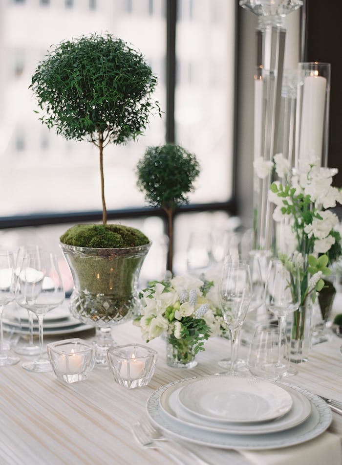 Stilvolle Tischdeko in Grün und Weiß, weiße Blumen und kleine Duftkerzen, Bonsai in Kristallvase