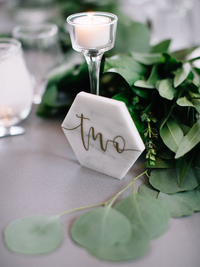 Simple und stilvolle Tischdeko für Hochzeit, kleine weiße Duftkerze, frische Blätter