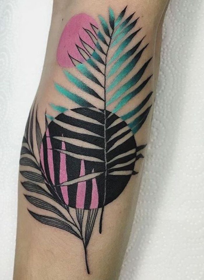 eine hand mit einem farbigen tattoo mit einer schwarzen sonne und mit blättern, watercolor tattoo ideen für frauen