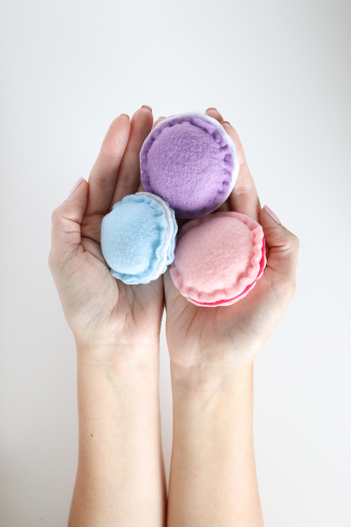katzenspielzeug selber basteln, selbstgemachte spielzeuge aus stoff in blau, lila und rosa, zwei hände