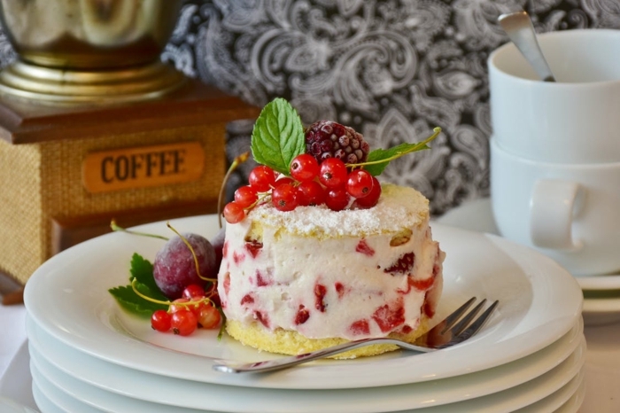 eine weiße Creme mit Erdbeeren Stücke darin, Geburtstagstorte Rezept, kleine Früchte als Dekoration