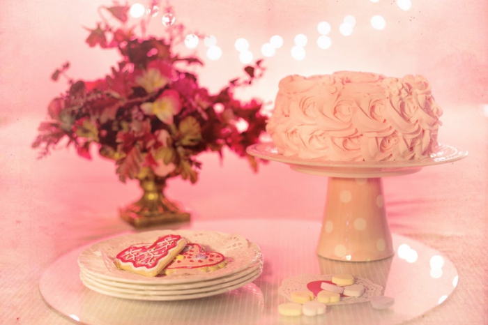 rosa Torte und rosa Plätzchen, rosa Bonbons, ein Blumenstrauß rosa Blumen, Deko für Babyparty