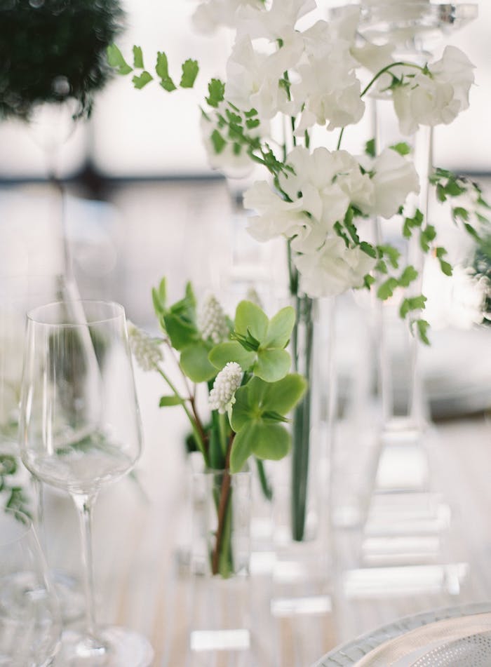 Weiße Blumen in Kristallvase, stilvolle Tischdeko für Hochzeit in Weiß