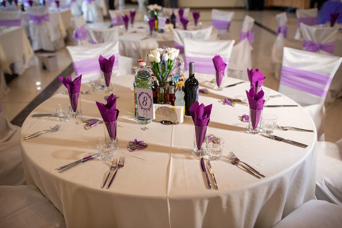 Tischdeko für Hochzeit in Weiß und Violett, weiße Decke und violette Servietten, weißer Tulpenstrauß