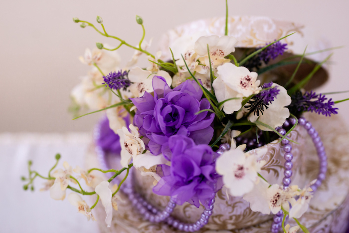 Dekoration für Hochzeit, weiße und lilafarbene Blumen und Perlen in Schachtel