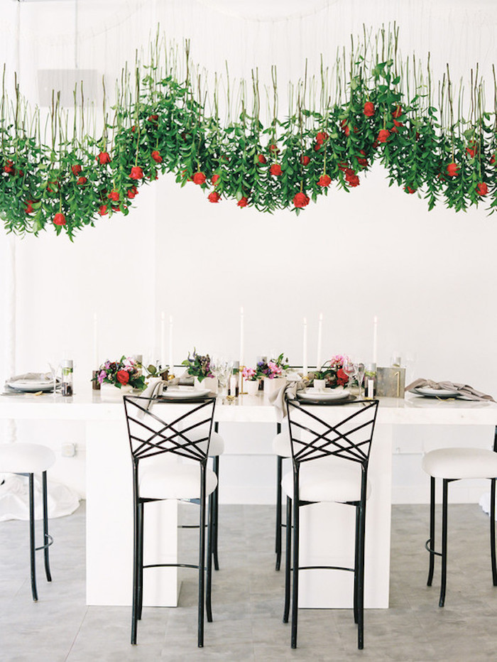 Kreative und ausgefallene Hochzeitsdekoration, rote Rosen in der Luft, weiße Kerzen