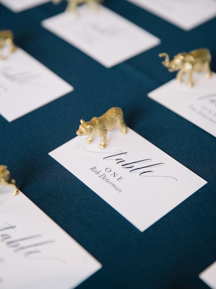 Zettel mit den Namen aller Hochzeitsgäste, kleine goldene Figuren, Ideen für Gastgeschenke