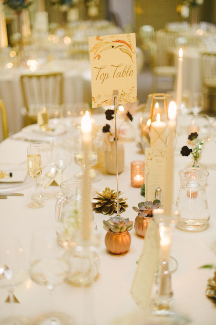 Stilvolle Tischdekoration für herbstliche Hochzeit in Golden, kleine Kürbisse und Zapfen