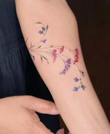 unterarm tattoo zarte blüten rot lila blau