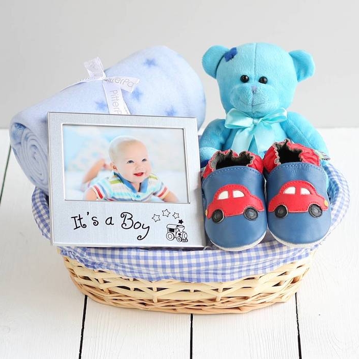 Idee für Taufgeschenk, Korb voller Geschenke, Baby Decke, blauer Kuschelbär, Babyschuhe und Bilderrahmen