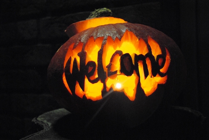 eine halloween dekoration mit einem großen orangen kürbis halloween mit einem welcome überschrift, einen kürbis schnitzen