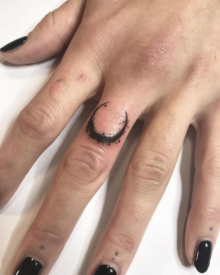Kleines schwarzes Tattoo am Mittelfinger, Mond Tattoo, schwarzer Nagellack
