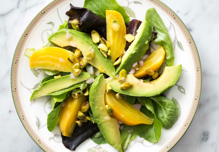 Avocado Mango Salat, Nüsse, Gartensalat in einem weißen Teller, rote Blätter