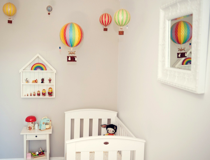 babyzimmer einrichten, baby geschenk basteln, viele bunte luftballons, spiegel mit großen rahmen, weißes babaybett
