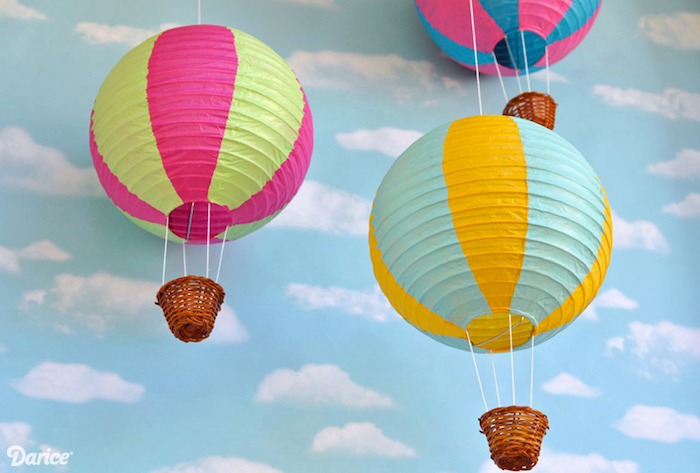 ballon bateln, tapete mit wolken, deko für das babyzimmer, kleine körbe, bunte papierlaternen