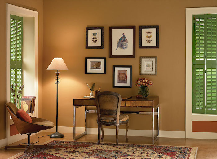 ein büro einrichten, ein stuhl mit einem kleinen orangen kissen und ein teppich, wanddekoration mit vielen bildern und eine weiße lampe, wand farbig streichen