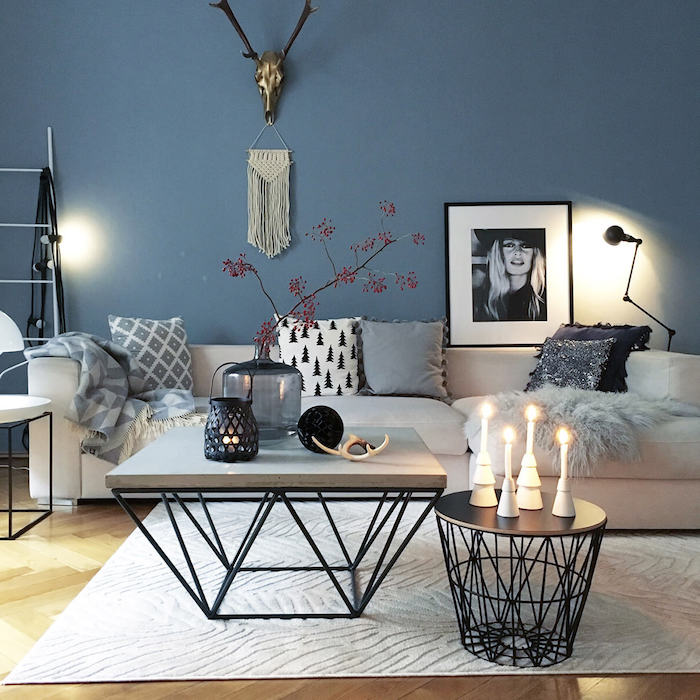 dekoartikel wohnzimmer, blaue wand, runder und eckiger kaffeetisch, kerzen und vasen