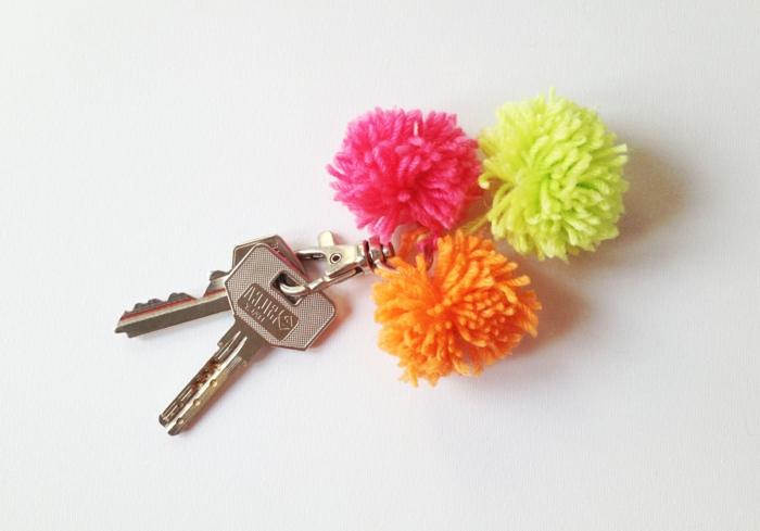 drei Quasten in rosa, grüner und oranger Farbe mit zwei Schlüssel, Schlüsselband selber machen