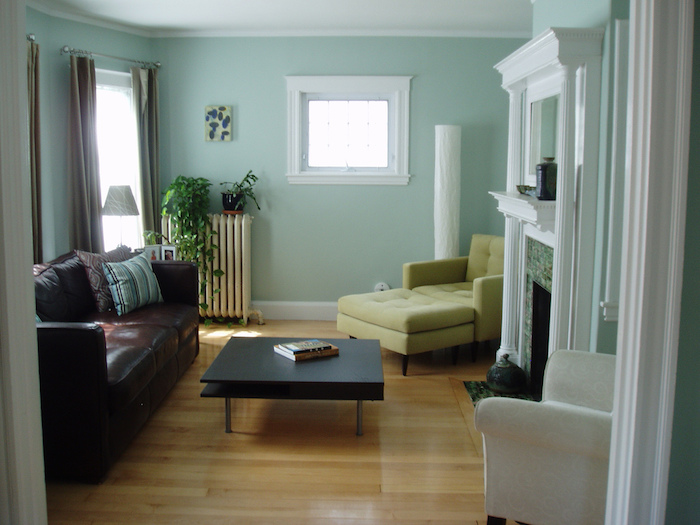 ein boden aus holz und ein wohnzimmer mit weißen und grünen und braunen sofas und mit einem kleinen schwarzen tisch und grünen wänden, wohnzimmer streichen ideen