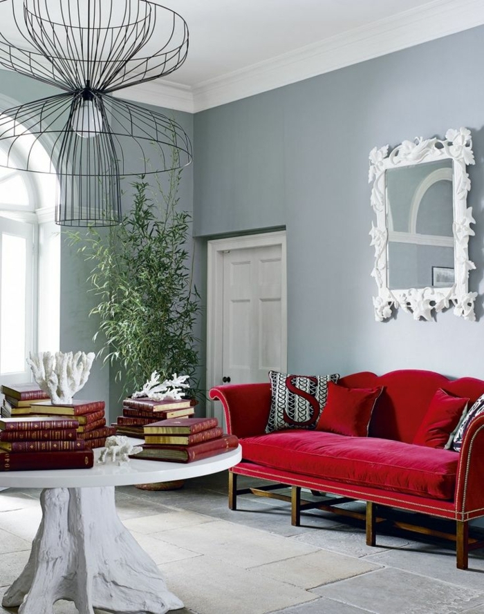 ein Spiegel mit weißer Rahmen, rotes Sofa, weißer Tisch, ausgefallener Lampenschirm, welche Farbe passt zu Grau