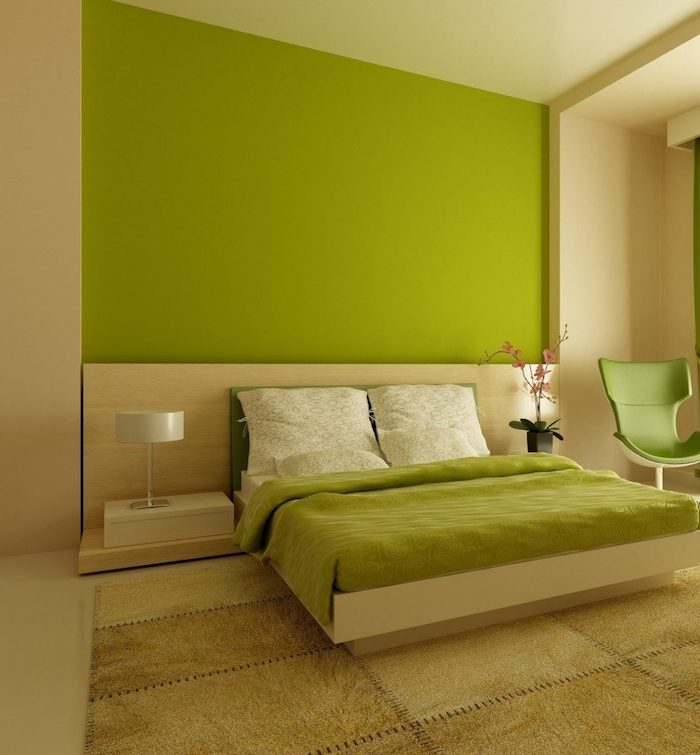 ein bett mit einer grünen decke und grünen kissen und eine schwarze vase mit pinken blumen, ein grüner stuhl und eine kleinen weiße lampe, wandfarbe grün schlafzimmer