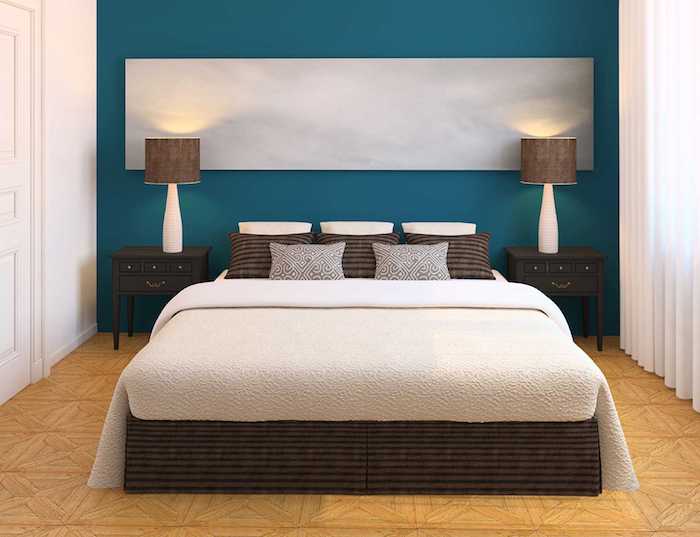 wandfarbe schlafzimmer, ein schlafzimmer mit einer blauen wand und mit einem bett mit braunen und weißen kisse, wand streichen ideen schlafzimmer