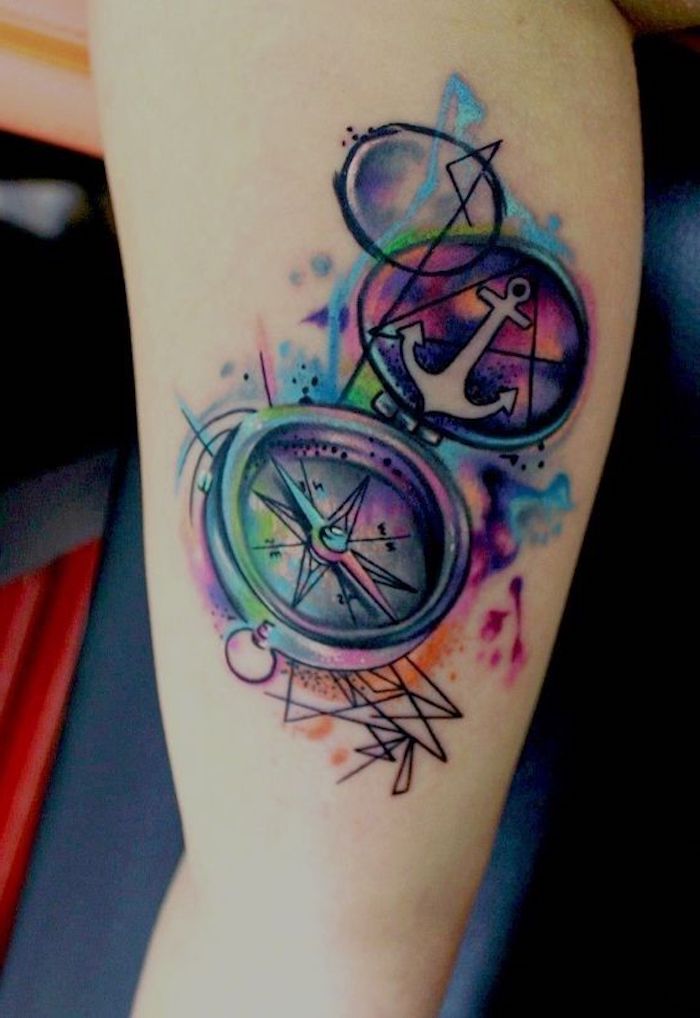 ein großes tattoo aquarell mit einem bunten kompass und mit einem kleinen weißen anker tattoo, frauen tattoo watercolor