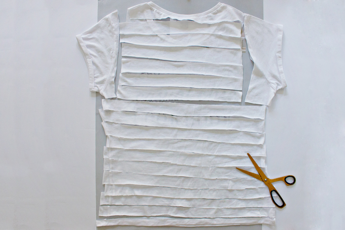 eine gelbe kleine schere und lange weiße streifen aus einem alten weißen t-shirt, geschenke selber basteln