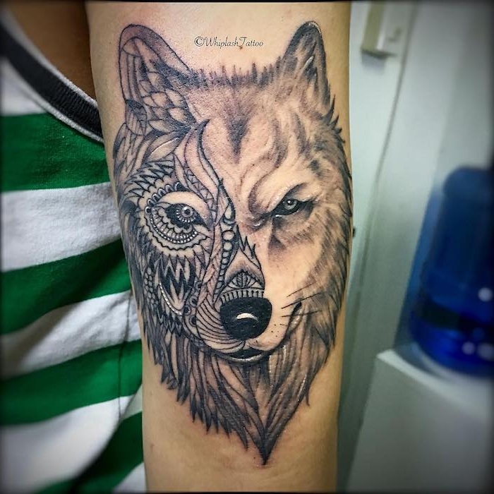 ein wolf tribal tattoo arm, ein mensch mit einem grünen unterhemd und mit einer hand mit einem tattoo mit einem wilden wolf