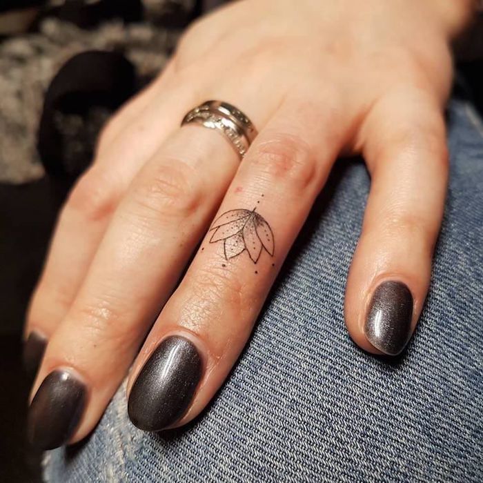 Lotus Tattoo am Ringfinger, Ideen für kleine Finger Tattoos, goldener Ring, schwarzer Nagellack