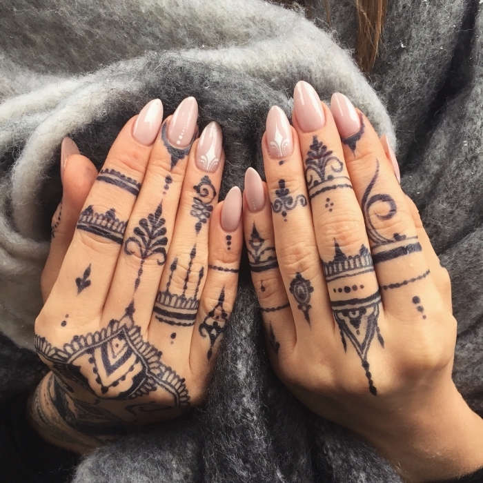 Henna Tattoos an bedien Händen, Nude-Nagellack, spitze Nägel, grauer Pullover