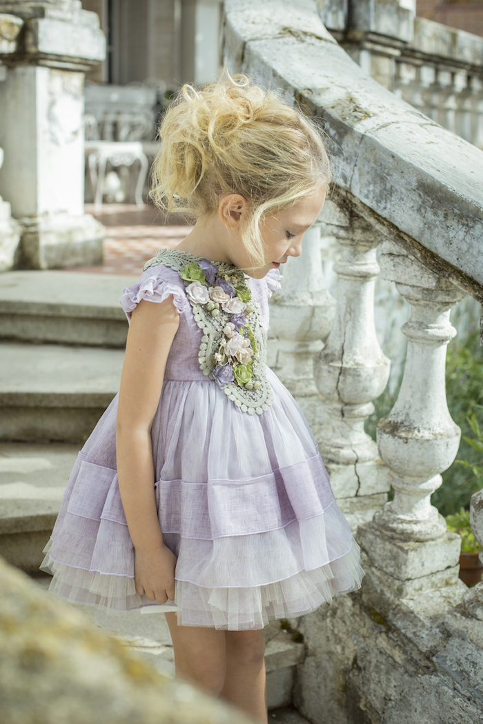 Kinderfrisuren für besondere Anlässe, Messy Dutt, lange blonde Haare, lilafarbenes Kleid mit Tüll und Blumen Applikationen