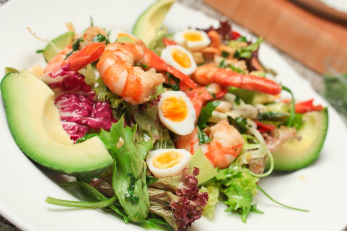 raffinierte Salate, kleine Eier, roter Kohl, Garnellen, ein Salat mit vielen gemischten Geschmäcken