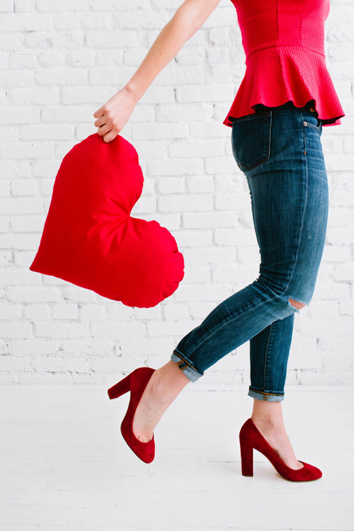 Herzförmiges Kissen, rote High Heels, Jeans und rotes Top, Outfit für Party zum achtzehnten Geburtstag