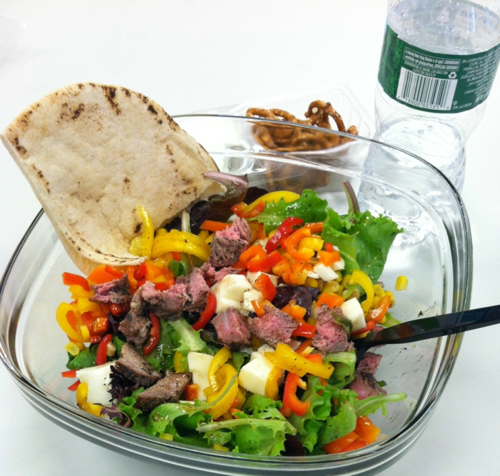 was ist gesunde ernährung, salatschüssel voll von grünsalat mit paprika, mozzarella, eier, tomaten und pitabrot als beilage