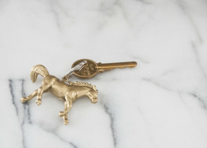 Schlüsselanhänger basteln, ein Pferdchen in goldener Farbe mit Schlüssel