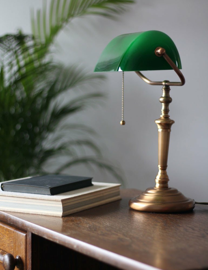 eine grüne gute Schreibtischlampe auf einem braunen Schreibtisch