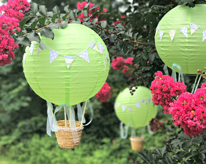 heißluftballon basteln, grüne laternen deoriert mit grilanden, kleine körbe, hängende gartendeko