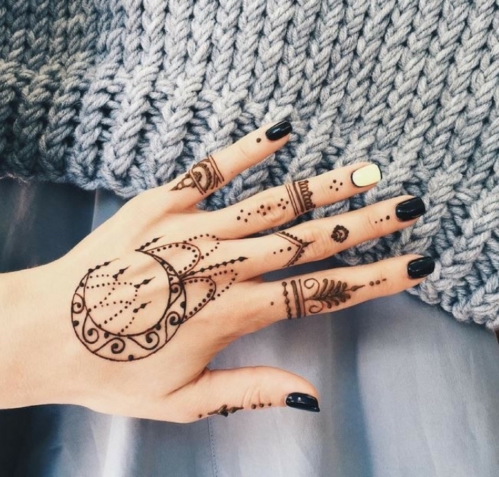 Schwarzes Henna Tattoo an der Hand, schwarzer Nagellack, ein weißer Nagel