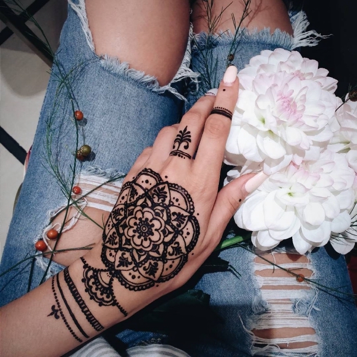 Schwarzes Henna Tattoo an der Hand, Mandala Blume, weißer Nagellack, weiße Chrysanthemen