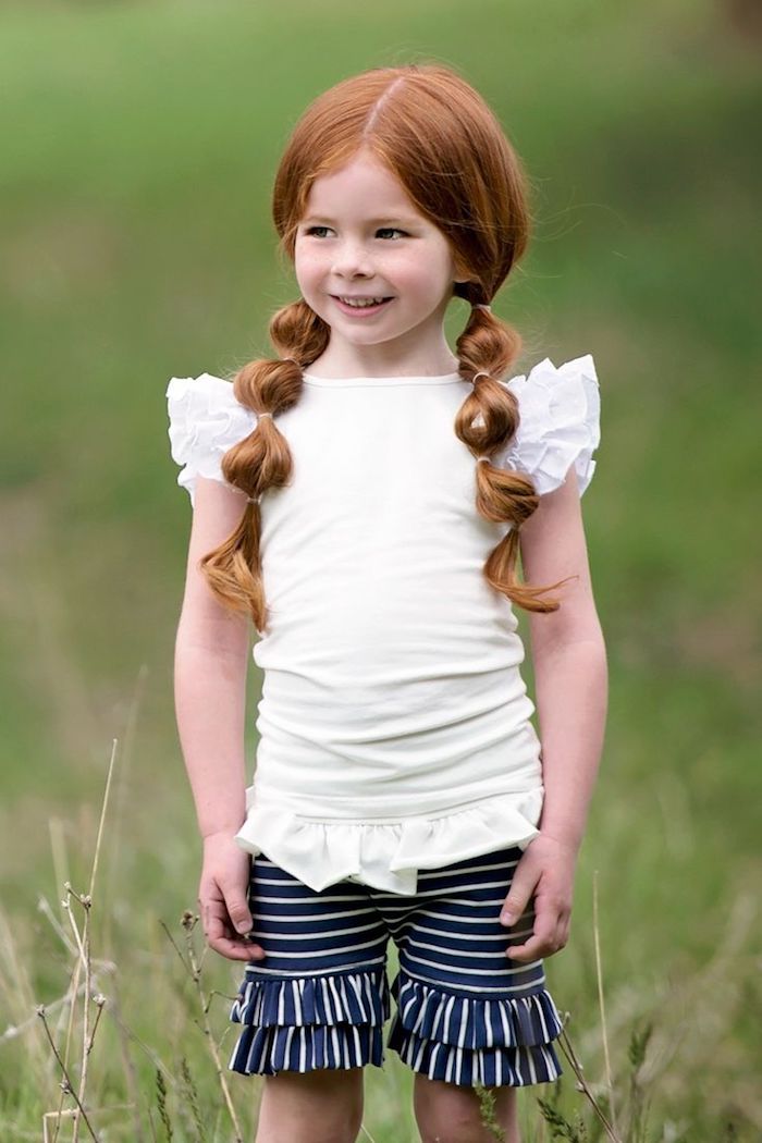 Schöne Kinderfrisur für lange Haare, zwei Zöpfe, weiße Bluse mit kurzen Ärmeln und gestreifte Hose