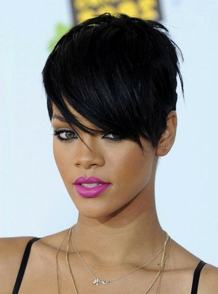Rihanna mit lila Lippenstift, kurze Haare, langer Pony, viele Ketten, kleine Ohrringe, moderne Ohrringe