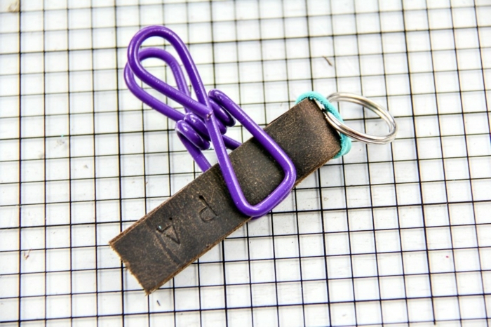 ein Streifen von Leder mit Wäscheklammern fixiert zum Trocknen, Schlüsselanhänger selber basteln