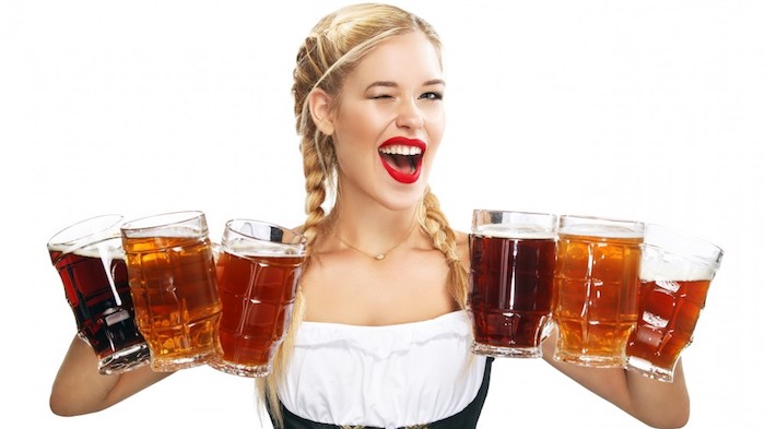 Blonde Frau in traditioneller bayerischer Trachtenkleidung, Bier servieren