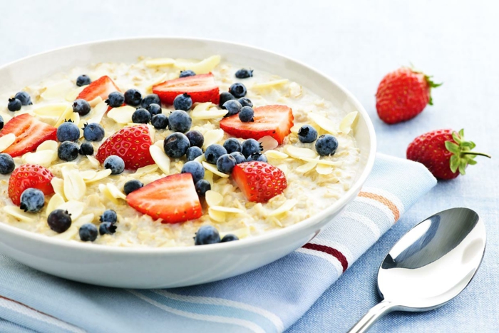 richtige ernährung heißt ein gesundes frühstück und auch nahrhaft, blaubeeren, erdbeeren und müsli mit milch oder joghurt